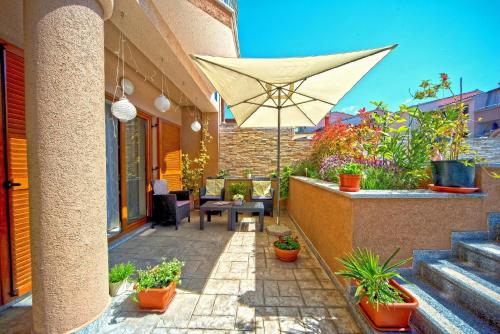 eine Terrasse mit einem Tisch und einem Sonnenschirm in der Unterkunft Studio für 4 Personen ca 56 qm in Pula, Istrien Istrische Riviera - b54701 in Pula