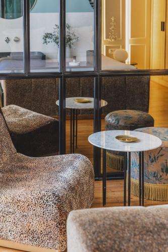 a room with two chairs and two tables at Hôtel Singulier Bordeaux - Boutique Hôtel & Spa Anne Semonin in Bordeaux