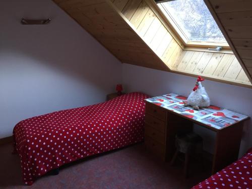 a bedroom with a red bed and a window at Appartement duplex pied des pistes et parking couvert in Arvieux