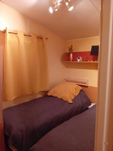 a bed with a yellow pillow in a room at ROUPILLON A JANET in Curvalle