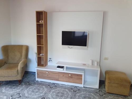 ein Wohnzimmer mit einem TV und einem Stuhl in der Unterkunft Center Lake House in Shkodra