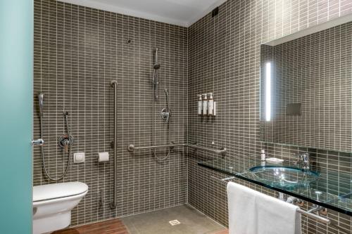 a bathroom with a shower and a toilet and a sink at AC Hotel Vicenza by Marriott in Vicenza