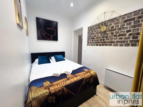 - une chambre avec un lit et un mur en briques dans l'établissement 90 - Karl Lagerfeld Lafayette, à Paris