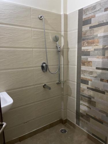 a shower in a bathroom with a glass door at Urban Oasis in Amritsar