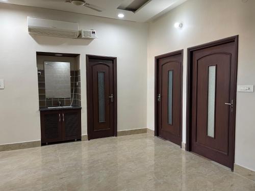 a bathroom with three wooden doors and a sink at Urban Oasis in Amritsar