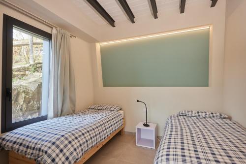 een slaapkamer met 2 bedden en een groot raam bij Agriturismo Rossolampone in San Bernardino Verbano
