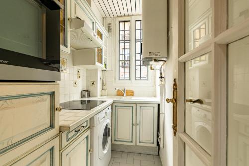 - une cuisine blanche avec un évier, un lave-linge et un sèche-linge dans l'établissement Calme et Cozy aux Portes de Paris, à Montreuil