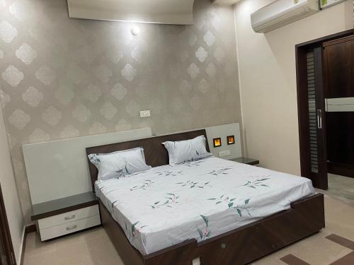a bedroom with a large bed with white sheets at Urban Oasis in Amritsar