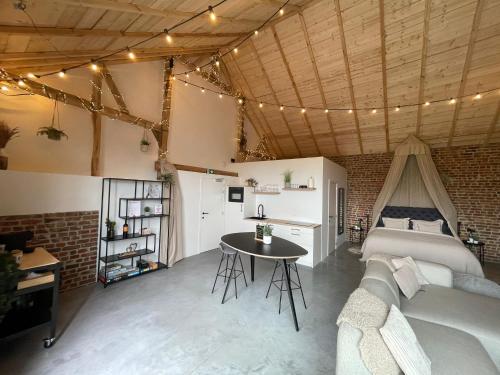 a living room with a couch and a table at Boven de paarden @ de Hoeveschuur in Riemst