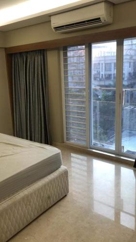 F1 apartments في مومباي: غرفة نوم بسرير ونافذة كبيرة
