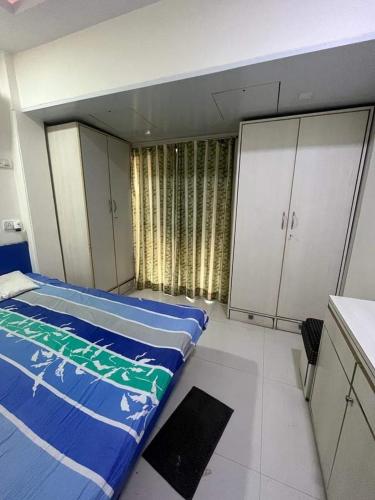 F1 apartments في مومباي: غرفة نوم فيها سريرين ودواليب بيضاء