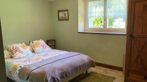 a bedroom with a bed with pillows and a window at La demeure romantique in Bazouges-sous-Hédé