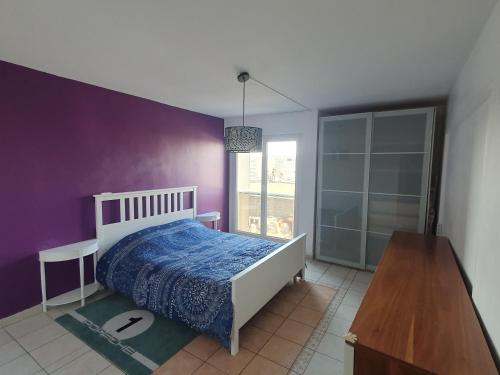 - une chambre avec un lit et un mur violet dans l'établissement A 30km de Paris, un bel appartement spacieux et convivial, à Boussy-Saint-Antoine