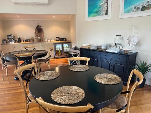 una sala da pranzo con tavolo e sedie neri di The Arabella North Coast a Wollongbar