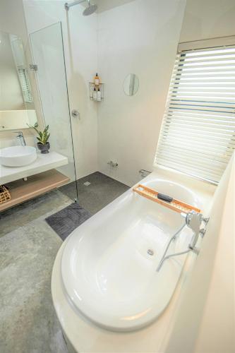 a white bathroom with a tub and a sink at Little Kubu Lodge in Hoedspruit