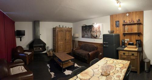 a living room with a refrigerator and a table at Appartement duplex pied des pistes et parking couvert in Arvieux