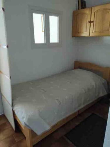 - un lit dans une chambre avec 2 fenêtres dans l'établissement Briançon studio à seulement 200m des pistes !, à Briançon