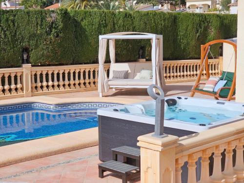 a jacuzzi tub in a patio next to a pool at Luxury Villa - pool, hot tub, aircon, TVs, home cinema, office, Gbit Internet, sports equipment, car in Calpe