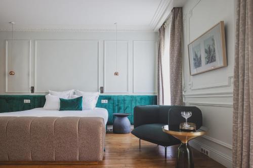 a hotel room with a bed and a chair at H&ocirc;tel Singulier Bordeaux in Bordeaux