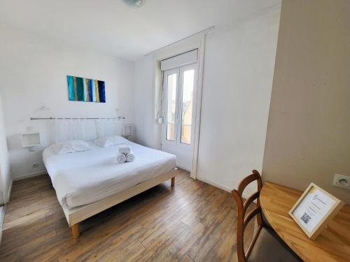 a white bedroom with a bed and a window at Allen - 2min de la plage du sillon et intra in Saint Malo