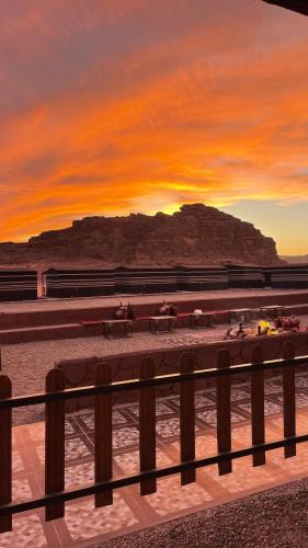 a sunset on the beach with people riding horses at Wadi Rum Magic Camp in Wadi Rum