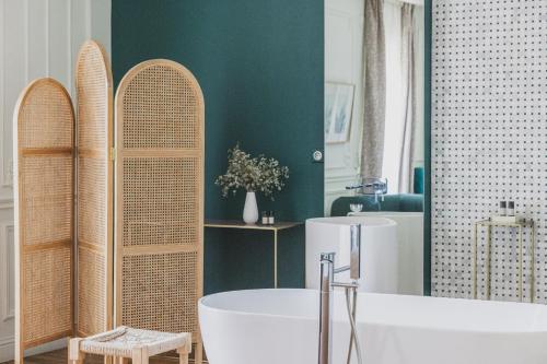 a bathroom with a white tub and a bath tub at Hôtel Singulier Bordeaux - Boutique Hôtel & Spa Anne Semonin in Bordeaux