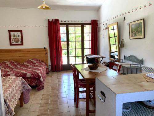 een slaapkamer met een bed en een tafel in een kamer bij Gîte La loge in Venasque