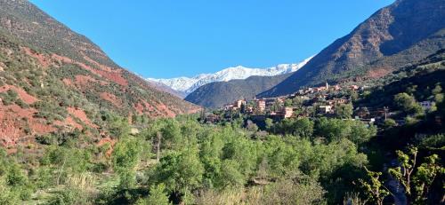 a village in a valley with mountains in the background at Country homes in Ourika