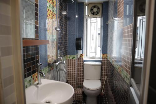 a bathroom with a toilet and a sink at Comfort Hostel in Hong Kong