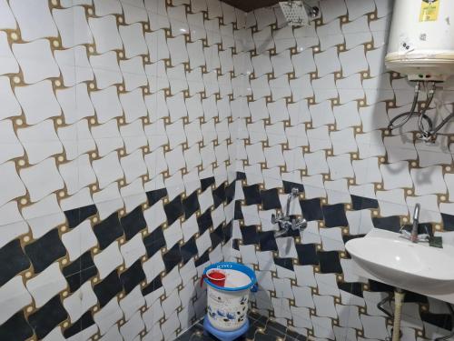 baño con lavabo y pared de azulejos blancos en Cascade Resort And Cottages en Mussoorie