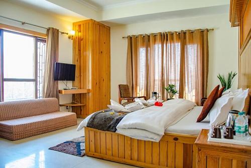 a bedroom with a large bed and a couch at Goroomgo Abhinandan Mall Road Mussoorie - Luxury Room - Excellent Customer Service Awarded - Best Seller in Mussoorie