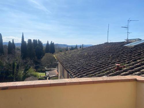 a roof of a house with trees and mountains in the background at Mansarda Salviatino in Florence