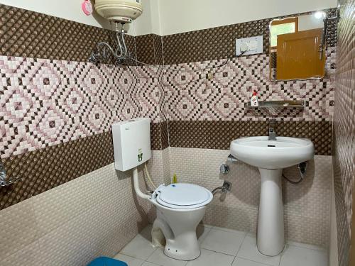 a small bathroom with a toilet and a sink at Highland spirit 2 in Kasol