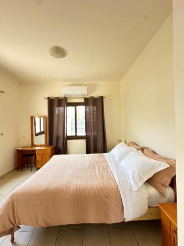 a bedroom with a bed with white sheets and a window at Relaxing Gateway in Limassol in Episkopi Limassol