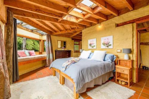 una camera con un letto e una grande finestra di Whare Aroha: Retreat to Wellness a Pakawau