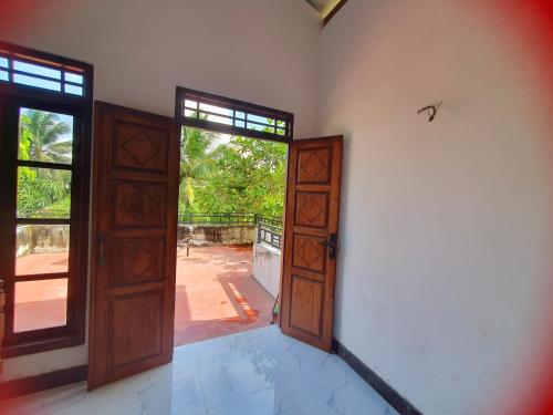 um quarto vazio com uma porta aberta para um pátio em Sky homestay em Ampara