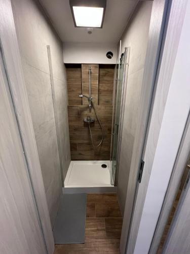 a bathroom with a shower with a glass door at Pokoje Brynów in Katowice