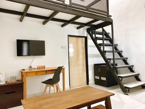 um quarto loft com uma secretária e uma escada em Rooma Kichi Private Pool em Pantai Cenang