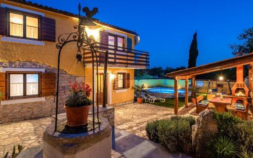 een huis met een patio en een zwembad bij Ferienwohnung für 5 Personen ca 60 qm in Mali Vareski, Istrien Südküste von Istrien in Mali Vareški