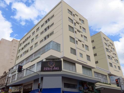a tall white building with a sign on it at Hotel Jaú by Easy Hotéis in Jaú