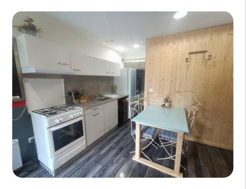 eine Küche mit einem Herd und einem Tisch darin in der Unterkunft Joli studio cosy in Combloux