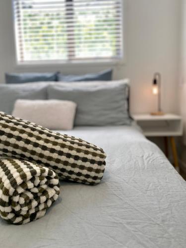 a bed with black and white pillows on it at The Views - Omokoroa in Omokoroa