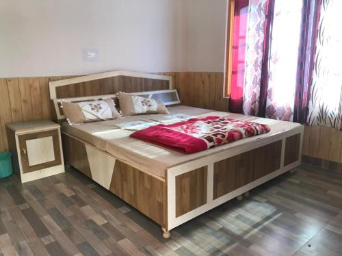 a large bed with a wooden frame in a room at Highland spirit 2 in Kasol
