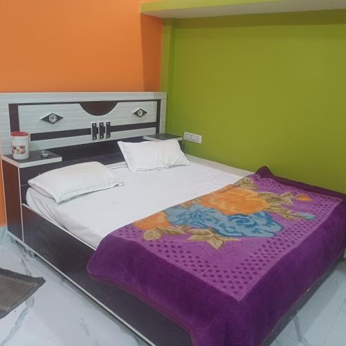 a bedroom with a large bed with a purple blanket at Maa Durga niwas home stey in Ayodhya