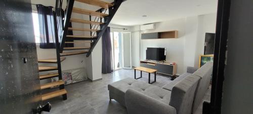 uma sala de estar com um sofá e uma escada em Immeuble Thala Duplex 135 m² em Tigzirt