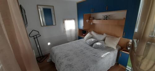- une petite chambre avec un lit aux murs bleus dans l'établissement T2 à 2 pas du centre-ville, à La Grande Motte