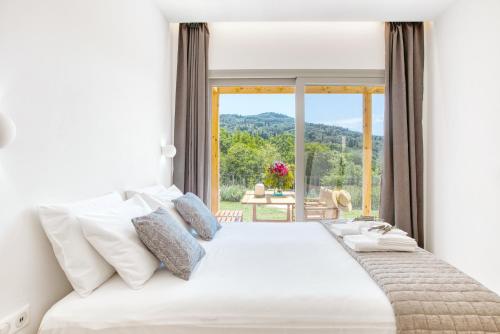 a bedroom with a large bed with a large window at Kumquart estate- Orange in Aspiotádes