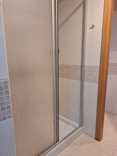 y baño con ducha y puerta de cristal. en Confortable flat in the city center, en Ceuta