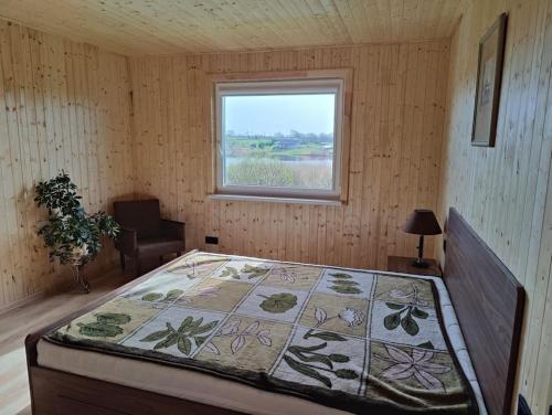a bedroom with a bed in a room with a window at Modern family house by the lake in Zarasai in Štadviliai
