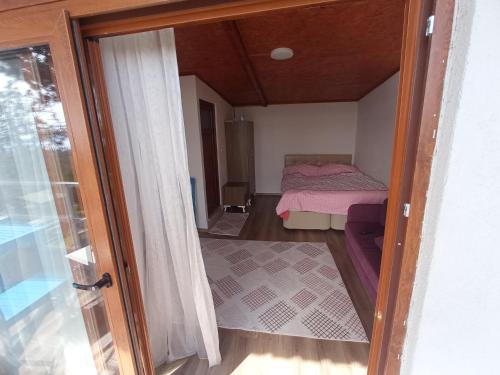 um pequeno quarto com uma cama e uma porta de vidro deslizante em ılıca anatolia pansiyon em Boyalıca